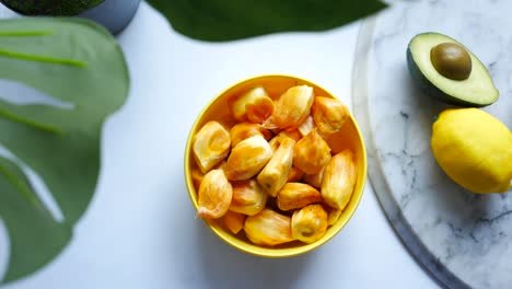 jackfruit, aguacate y limón en una mesa blanca