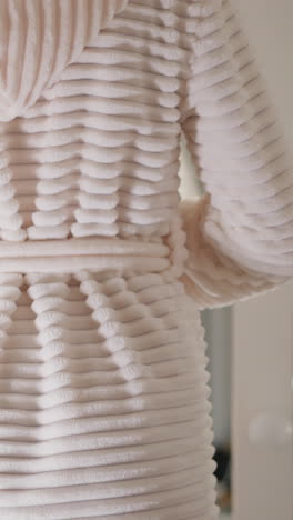 la dama se pone una acogedora túnica de baño cálida después de los tratamientos de la noche. la hembra lanza una túnica de terry sobre el cuerpo atando con un cinturón después de tomar la ducha en cámara lenta