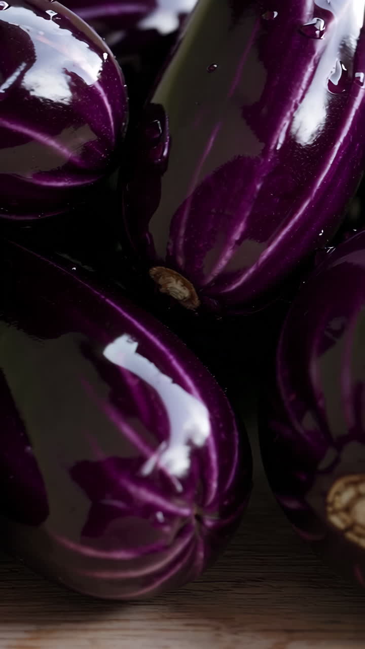 Färska lila äggplantor med vattendroppar