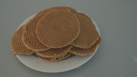 top down dolly of pile of stroopwafels on white plate