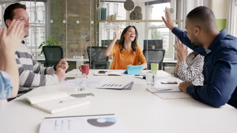 gente de negocios diversa aplaudiendo en una reunión de equipo creativo celebrando el éxito en una sala de juntas de oficina moderna casual con luz natural y grandes ventanas abiertas