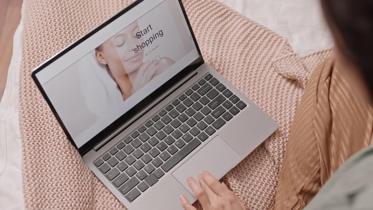 Woman shopping online with laptop in bed