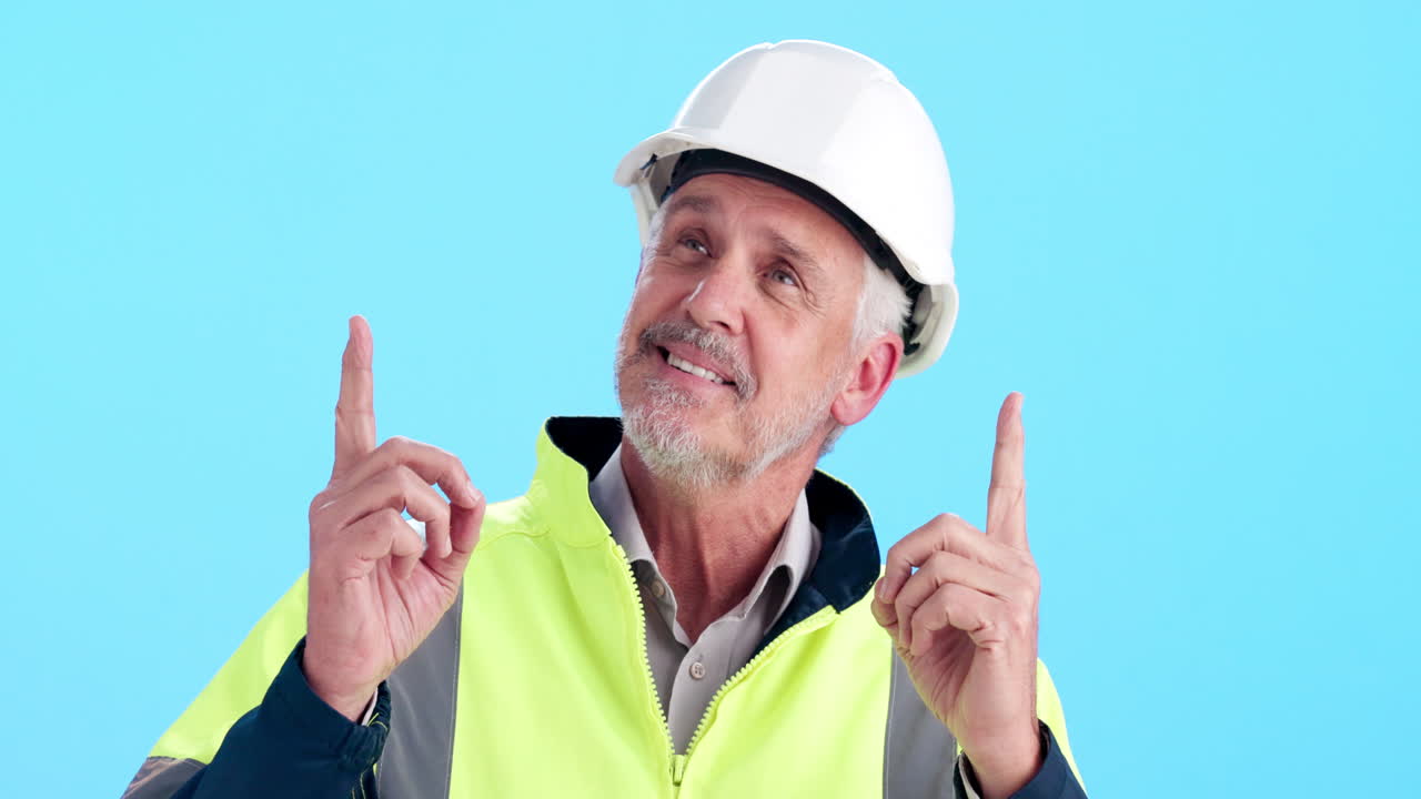 Construction worker pointing upwards on blue background