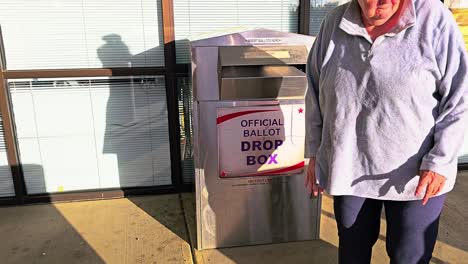 old woman votes in election by mail at official ballot drop box sign for american democratic government presidential race by casting ballot in slot, mail-in letter