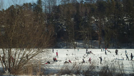 picturesque view of crowd of people ice skating, enjoying frozen lhotka lake in harasov, kokorin, czech republic - wide slow-motion panning shot