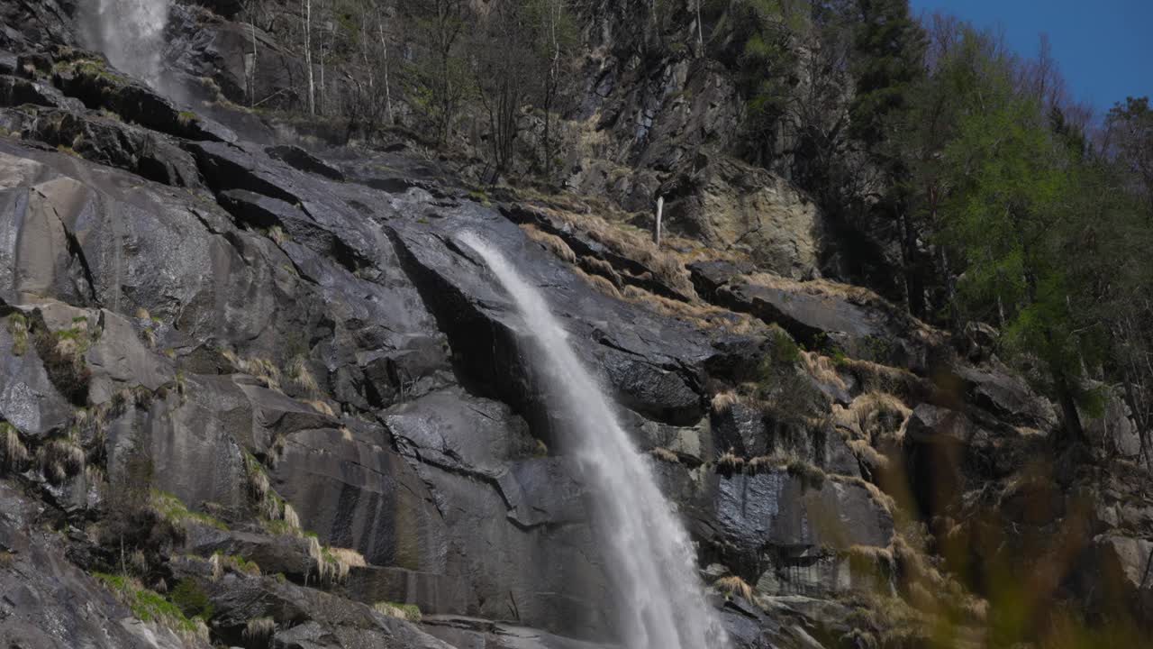 Steinete turstier med Nardis-fossene i Genova-dalen, Trentino, Italia