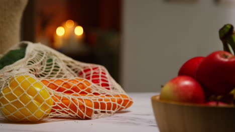 close up de una mujer desempaquetando una bolsa de frutas y verduras frescas y saludables en el mostrador en la cocina 4