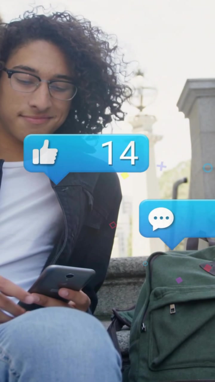 Vertical video: Man sitting on step tapping phone, causing social media bubbles circling backpack