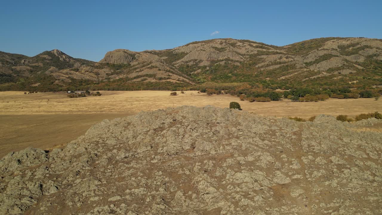 vuela sobre laderas rocosas con crestas montañosas en el fondo