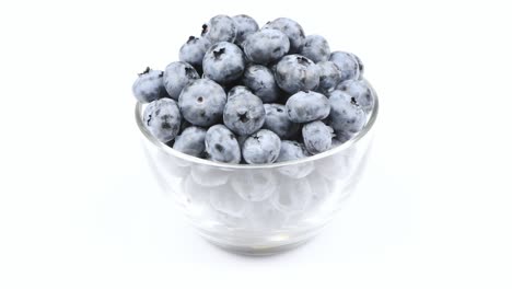 blueberries in a glass bowl on a white background. side view. loop motion. rotation 360.