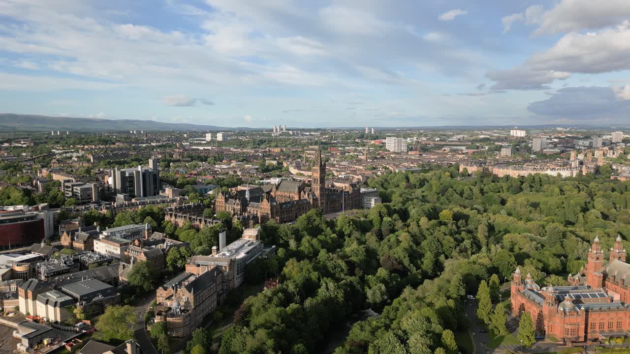 Aerial fly towards Glasgow University on top of hill surrounded by greenery on a sunny evening, Glasgow, Scotland, UK