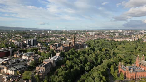 aerial fly towards glasgow university on top of hill surrounded by greenery on a sunny evening, glasgow, scotland, uk