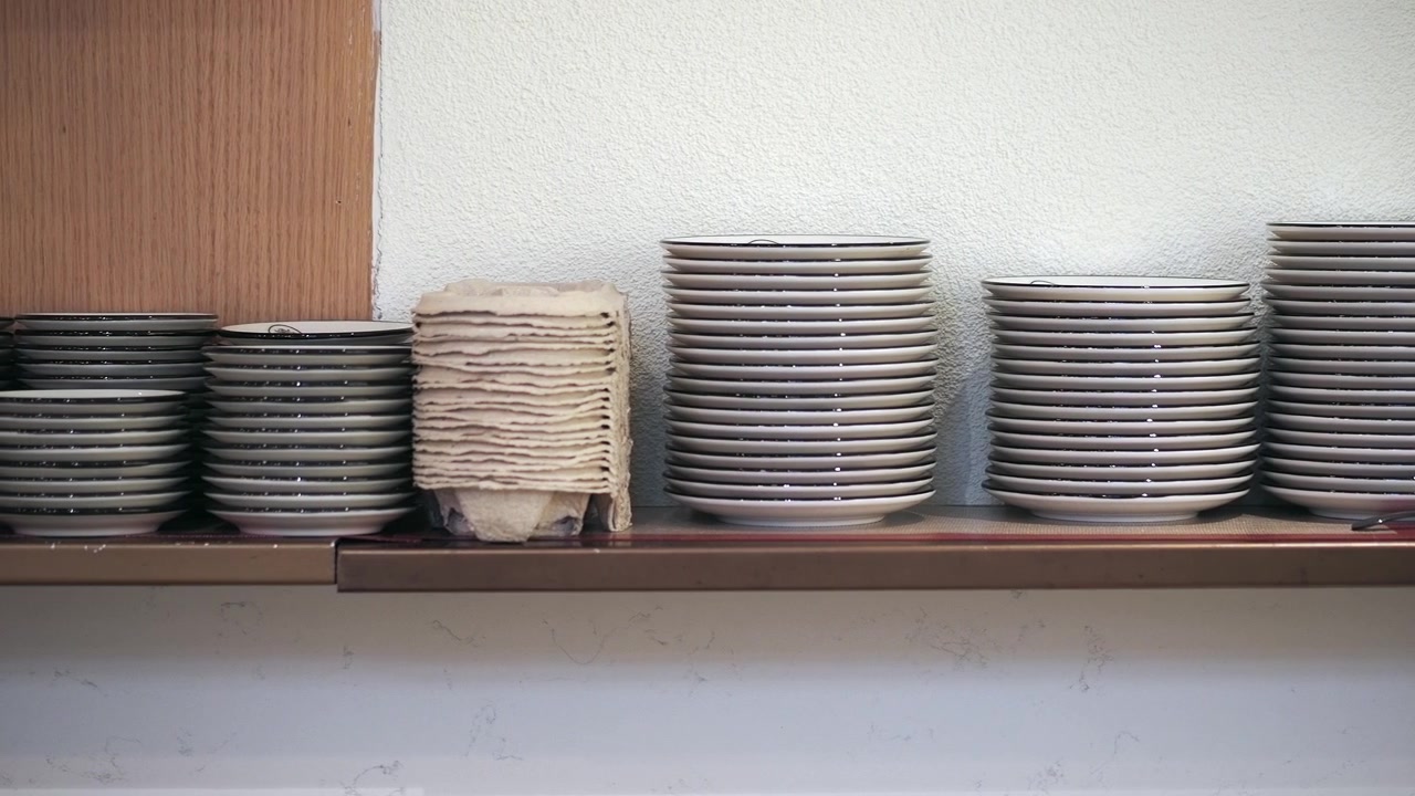 Stacks of Clean Ceramic Plates on a Kitchen Shelf