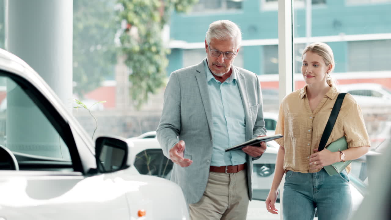 A car salesman talking with a customer at a car dealership