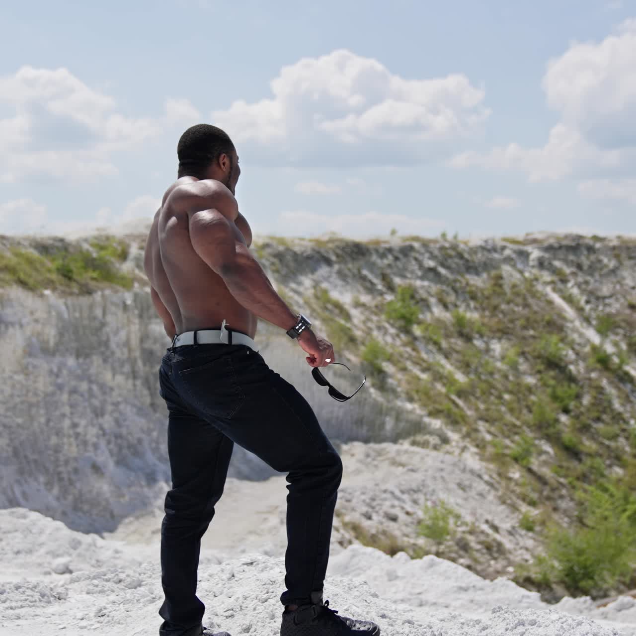 Full length view of the muscular handsome man with naked torso outdoor. Athletic naked man standing outside and looking at the views