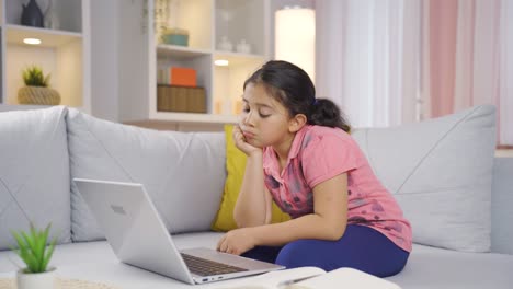 una niña mirando una computadora portátil es cuidadosa.