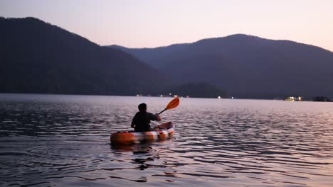 two people kayaking together on a calm lake at twilight.