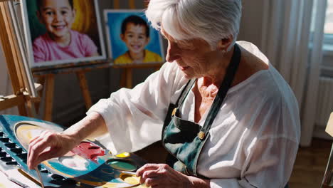 elderly woman painting a portrait in art studio