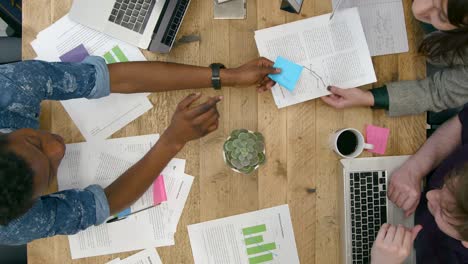 Overhead-View-Of-Colleagues-Working-Together-At-Table