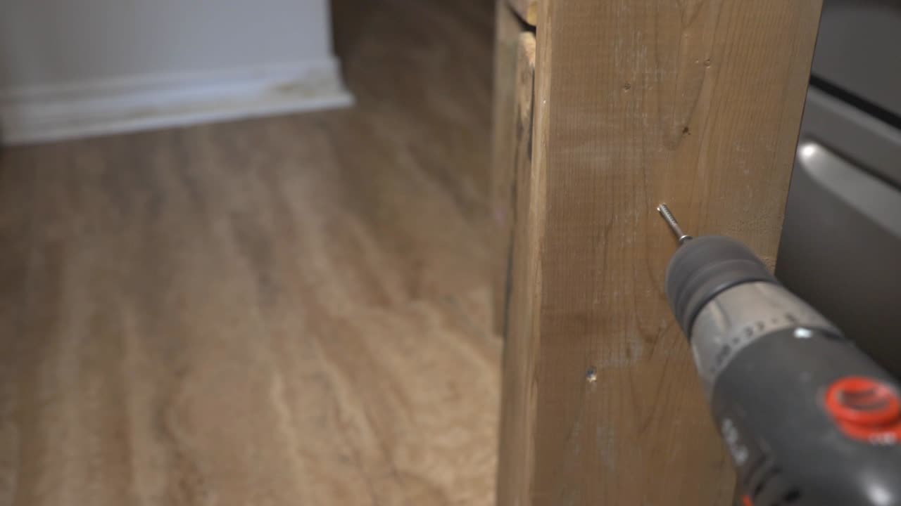 Drilling A Screw Into The Wooden Plank. Woodworking. - close up shot