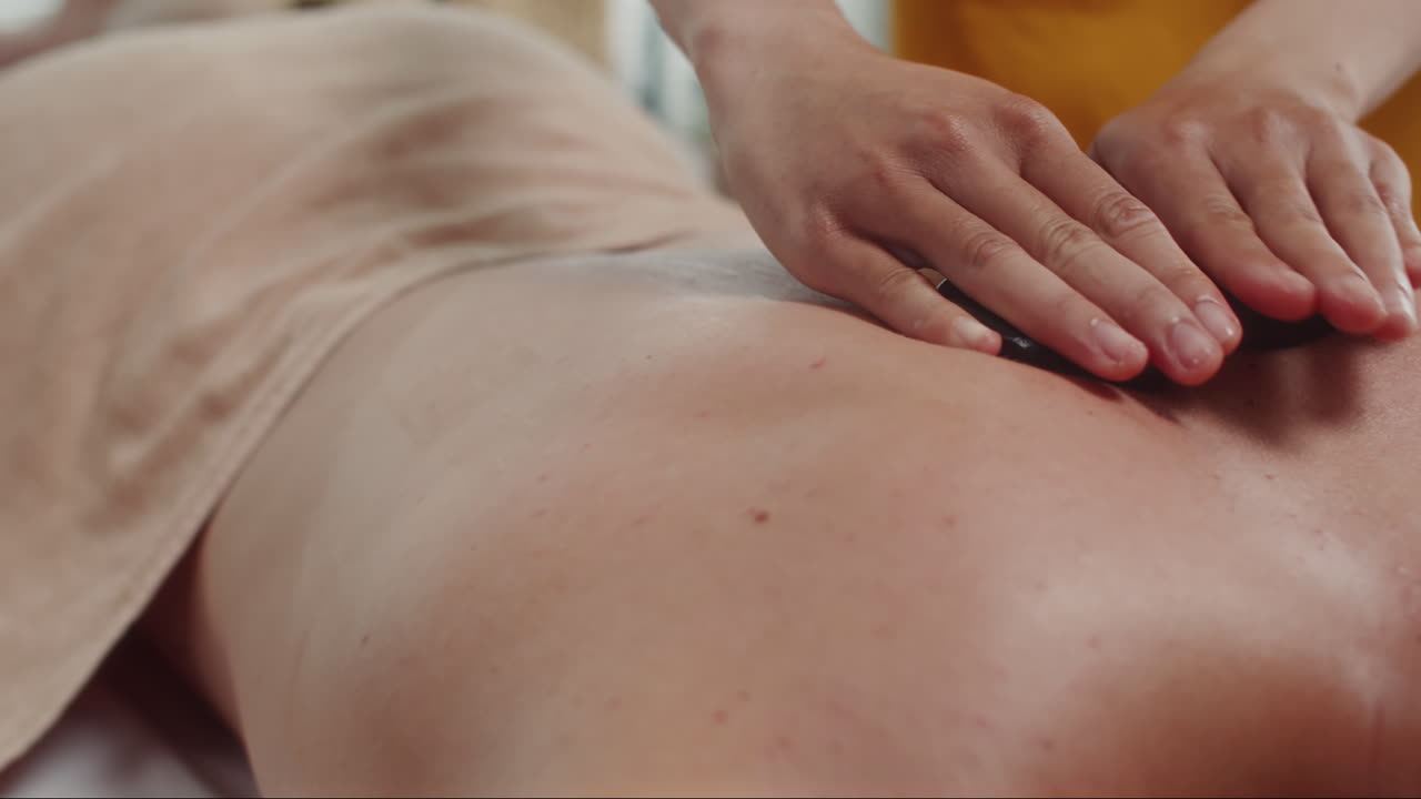 Male Client Lying on Couch during Massage with Hot Stones