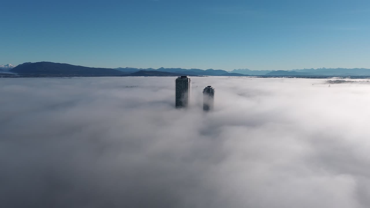 Grattacieli sopra una fitta coltre di nebbia a Langley, Columbia Britannica, Canada. Ampia ripresa con drone.