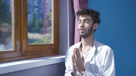 hombre en meditación frente a la ventana.