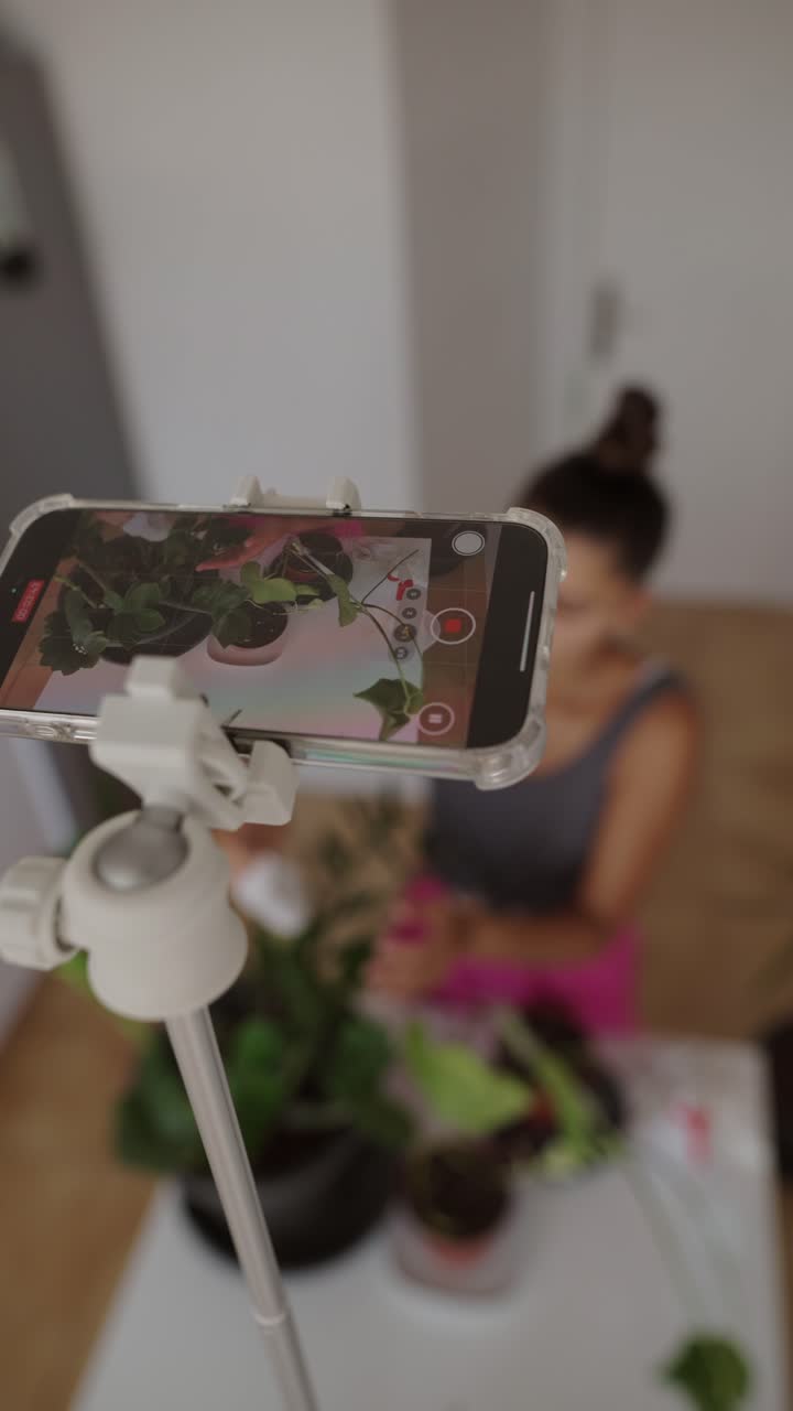 Woman recording video of plants