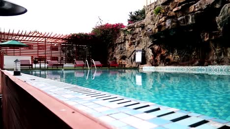 Crystal-blue-water-within-a-private-pool-with-some-sun-loungers-and-rock-walls