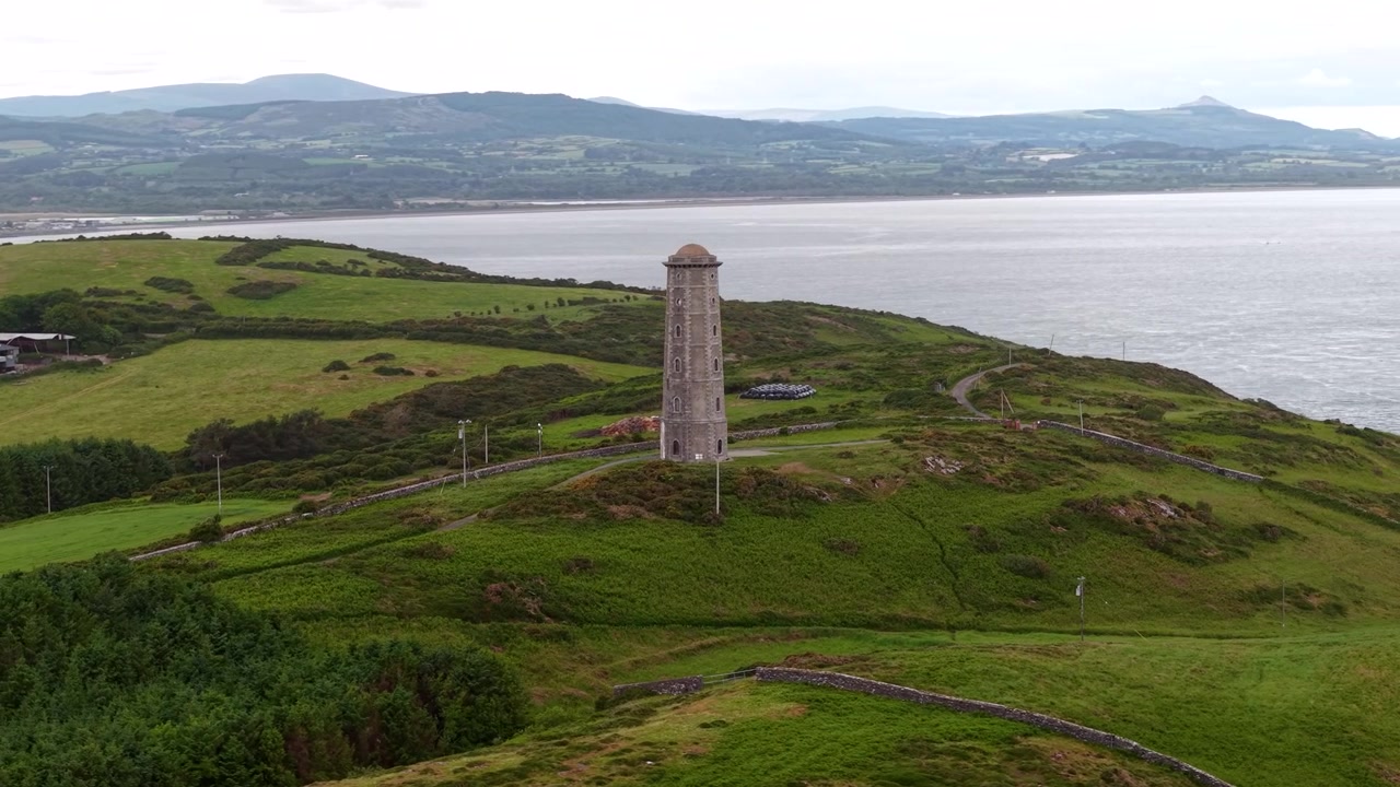 Bredt luftfoto af Wicklow Head Front Fyr og barsk kystlandskab i Irland