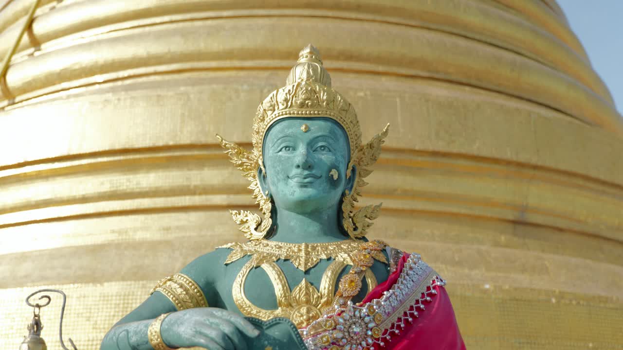 Footage of a Green Buddha statue in front of the golden stupa on top of Wat Saket, also known as the Golden Mount, in downtown Bangkok, Thailand. A famous Buddhist temple and landmark