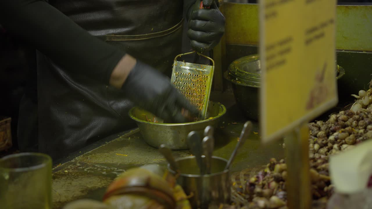 Hands In Black Gloves Grating Turmeric For Jamu - Traditional Herbal Drink At Market Stall In Indonesia. closeup shot