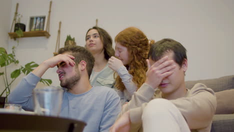 fanáticos de deportes tristes viendo la televisión y molestándose por la derrota de los equipos