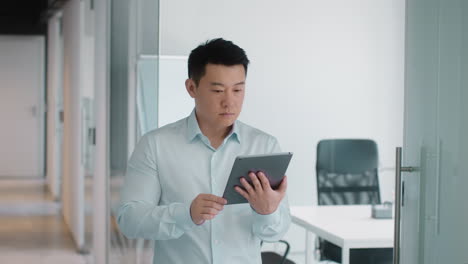 businessman using tablet in office corridor