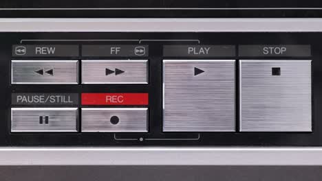 Extreme-close-up-of-buttons-on-an-old-antique-or-vintage-VCR-pushing-stop-from-either-side