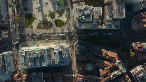 Aerial-birds-eye-overhead-top-down-ascending-footage-of-vehicles-driving-on-busy-roads-around-high-rise-buildings-at-Spain-square.
