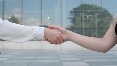 Mujeres-Dándose-La-Mano-Después-De-La-Entrevista-Cerca-Del-Edificio-De-Oficinas