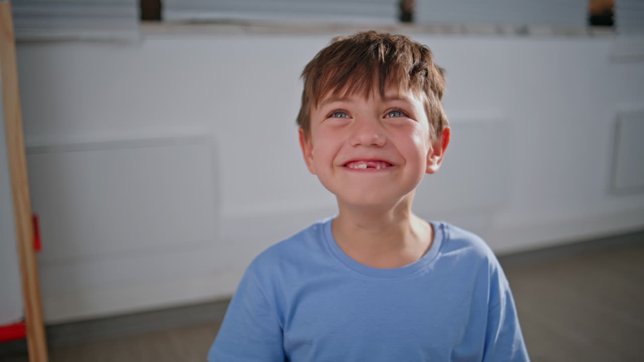 Closeup funny pupil boy fooling around at school. Happy kid showing fun faces