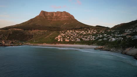 table mountain overlooking llandudno beach at sunset in cape town, aerial