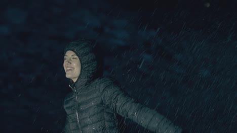 pretty lady screams with happiness in heavy rain at night