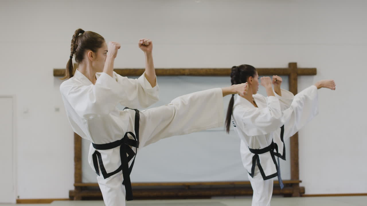 Two girls practising kicks and punches