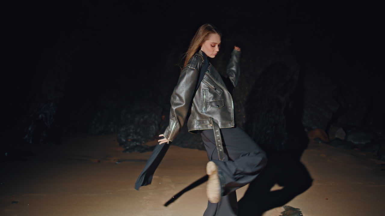 Fashion girl modeling beach in jacket at night zoom on. Woman spinning in dance
