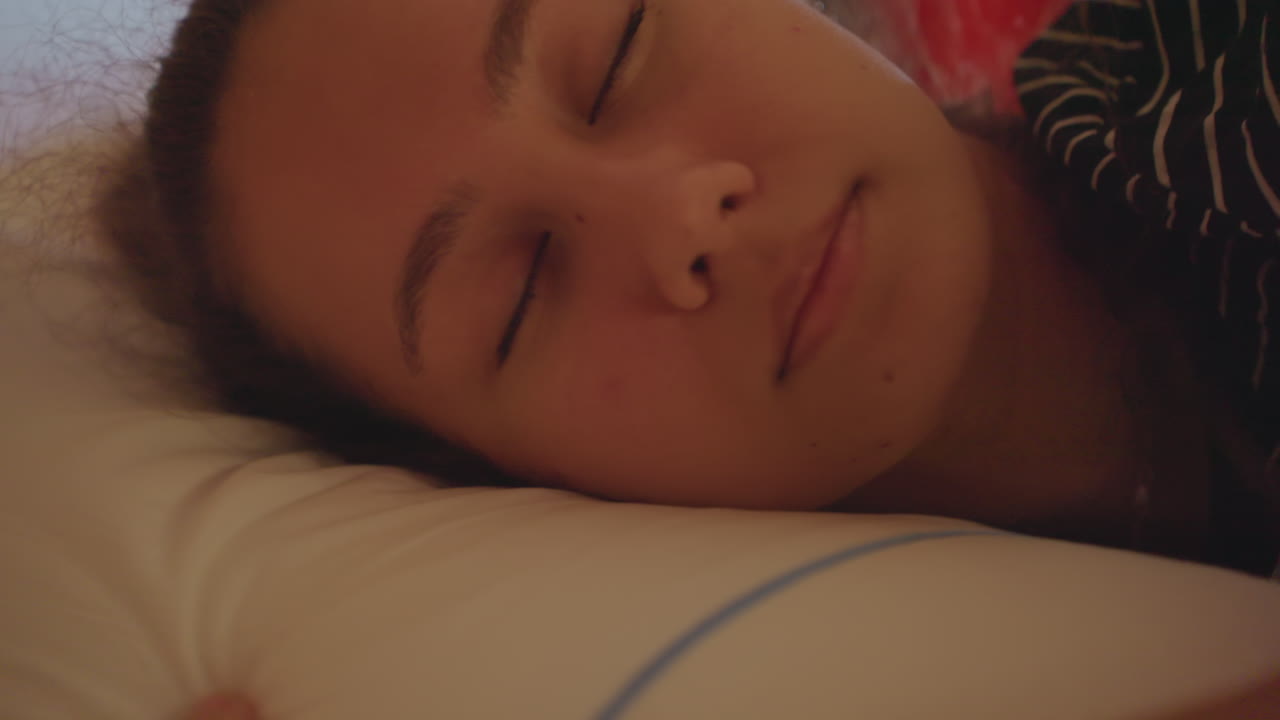 Riposo rilassato in hotel. Donna che riposa tranquillamente in un ambiente alberghiero. Profilo sereno di una donna in un ambiente tranquillo d'hotel. Primo piano di una donna distesa serenamente con gli occhi chiusi in una tranquilla camera d'albergo
