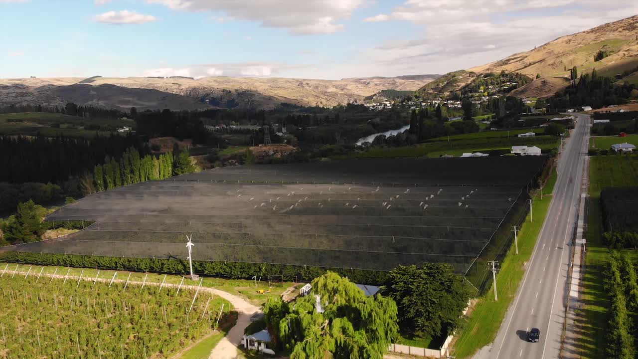 Fruit orchard covered with black shade cloth to protect from sunlight, aerial