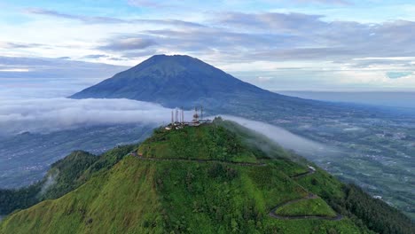 Drone scenery of the top Telomoyo Mountain in beautiful cloudy morning with Mt. Merbabu on the background. Amazing Indonesia nature landscape.