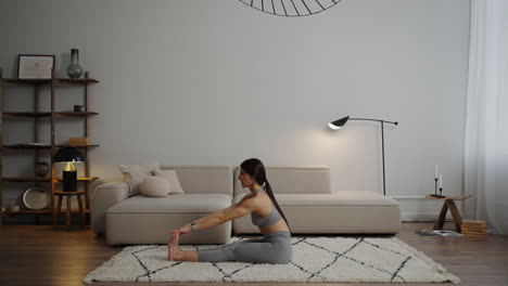 woman doing seated stretches at home