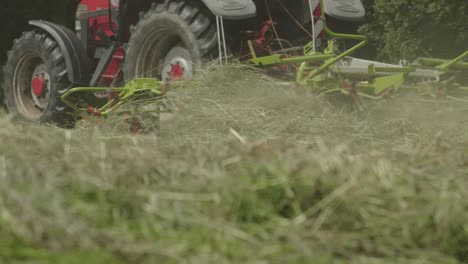 low angle of tractor mowing grass in property field