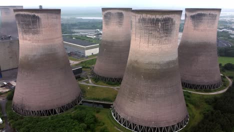 disused industrial energy power plant cooling smoke stake chimneys aerial view slow push between