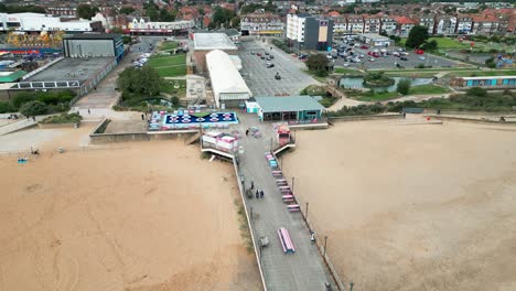 Küstenresort-An-Der-Ostküste,-Aufgenommen-Mit-Einer-Drohne,-Die-Einen-Hohen-Luftbildpunkt-Bietet,-Der-Einen-Weiten-Sandstrand-Mit-Einem-Pier-Und-Tosenden-Wellen-Zeigt