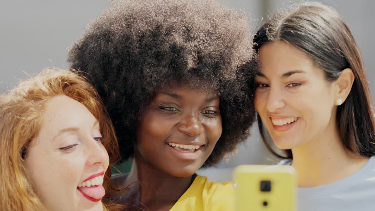 Three diverse women taking a happy selfie